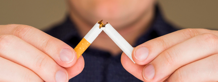 Man breaking a cigarette in half