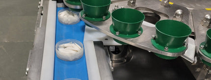 nicotine pouches on metal conveyor belt in factory setting