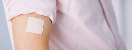 nicotine patch on person’s bicep, pink shirt rolled above it